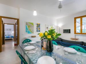 Una mesa de comedor con un jarrón de flores encima. en Apartment I Pini by Interhome, en Castiglioncello 36 fotos más