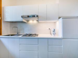 eine weiße Küche mit weißen Schränken und einem Waschbecken in der Unterkunft Apartment I Pini by Interhome in Castiglioncello