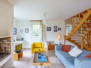 uma sala de estar com um sofá azul e uma escada em Holiday Home Maison bleue by Interhome em Kernalléguen