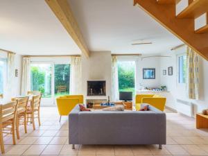 uma sala de estar com cadeiras amarelas e um sofá cinzento em Holiday Home Maison bleue by Interhome em Kernalléguen