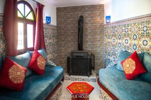 a living room with two blue couches and a stove at BELLEVUE HOUSE - with terrace in the heart of medina in Chefchaouene