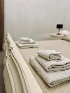 a pile of towels sitting on a bed at Casa Bianca Soave in Soave