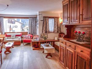 uma cozinha e sala de estar com um sofá e uma mesa em Apartment Chesa Arlas E2 by Interhome em St. Moritz