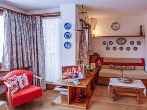 uma sala de estar com uma cadeira vermelha e um sofá em Apartment Chesa Arlas E2 by Interhome em St. Moritz
