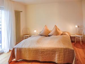 Schlafzimmer mit einem Bett, einem Tisch und einem Fenster in der Unterkunft Apartment Chesa Vuorcha by Interhome in Zuoz