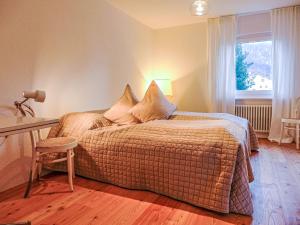 a bedroom with a bed and a desk and a window at Apartment Chesa Vuorcha by Interhome in Zuoz