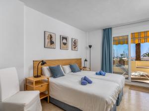 エステポナにあるApartment Puerto Paraíso III by Interhomeのベッドルーム1室(大型ベッド1台、青い枕付)