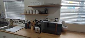 a kitchen counter with a sink and a microwave at Lasai Accommodation in Worcester