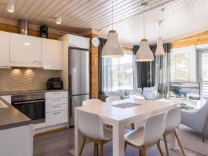 a kitchen and dining room with a table and chairs at Holiday Home Villa ukkohalla by Interhome in Ukkohalla