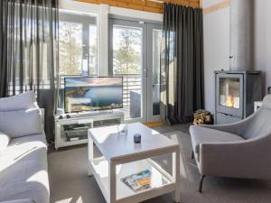 a living room with a couch and a tv at Holiday Home Villa ukkohalla by Interhome in Ukkohalla +21 photos