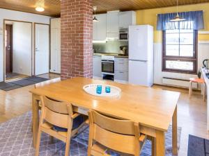 a kitchen with a wooden table and chairs at Holiday Home Villa-lyydia by Interhome in Niemikylät