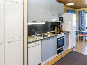 a kitchen with white cabinets and a sink at Holiday Home Villa-lyydia by Interhome in Niemikylät