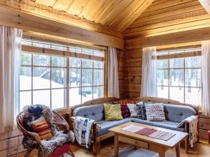 ein Wohnzimmer mit Sofa und Tisch in der Unterkunft Holiday Home Outarinne by Interhome in Ylläsjärvi