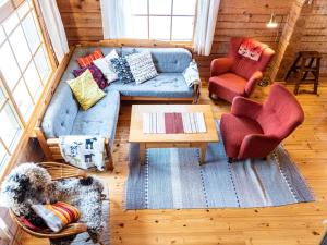 ein Wohnzimmer mit einem blauen Sofa und 2 Stühlen in der Unterkunft Holiday Home Outarinne by Interhome in Ylläsjärvi
