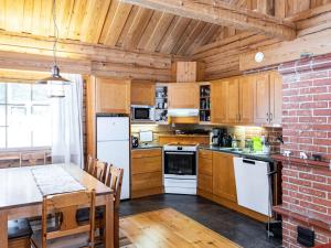 eine Küche mit einem Tisch und einer Ziegelwand in der Unterkunft Holiday Home Outarinne by Interhome in Ylläsjärvi + 19 Fotos
