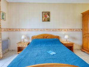 ein Schlafzimmer mit einem blauen Bett und zwei Nachttischen in der Unterkunft Holiday Home Y Sian Ben by Interhome in Lacanau-Océan