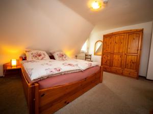 Schlafzimmer mit einem Holzbett und einem Holzschrank in der Unterkunft Holiday Home Haus am Berg der Osterräder by Interhome in Lügde