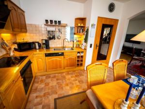 eine Küche mit Holzschränken und einem Tisch und Stühlen in der Unterkunft Holiday Home Haus am Berg der Osterräder by Interhome in Lügde