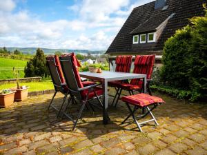 einen Tisch und vier Stühle auf einer Terrasse in der Unterkunft Holiday Home Haus am Berg der Osterräder by Interhome in Lügde