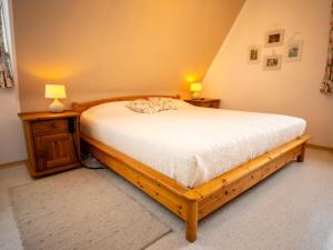 ein Schlafzimmer mit einem Holzbett und zwei Nachttischen in der Unterkunft Holiday Home Haus am Berg der Osterräder by Interhome in Lügde