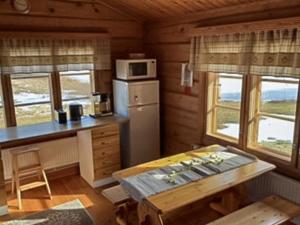 a kitchen with a refrigerator and a table in a room at Holiday Home Rantatalo by Interhome in Hirsjärvi