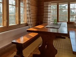 a wooden table in a room with windows at Holiday Home Rantatalo by Interhome in Hirsjärvi