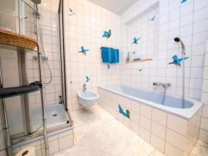 ein Badezimmer mit Badewanne und Toilette in der Unterkunft Holiday Home Haus am Berg der Osterräder by Interhome in Lügde