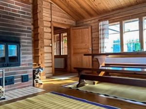 ein Wohnzimmer mit einem Kamin und einem Klavier in der Unterkunft Holiday Home Rantatalo by Interhome in Hirsjärvi