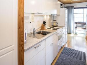 uma cozinha com armários brancos e um lavatório em Holiday Home Pikku-puntila by Interhome em Niemikylät
