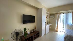 a living room with a flat screen tv on the wall at Condo Unit near Ayala Serin Mall in Tagaytay