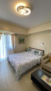 1 dormitorio con 1 cama grande y 1 sofá en Condo Unit near Ayala Serin Mall, en Tagaytay
