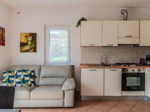 uma sala de estar com um sofá e uma cozinha em Apartment Pieve by Interhome em Gravedona