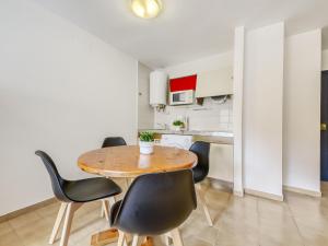 ロザスにあるApartment Mismar-3 by Interhomeのキッチン、ダイニングルーム(木製のテーブルと椅子付)