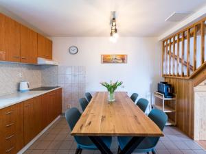 cocina con mesa de madera y sillas azules en Holiday Home Holiday Hill 30 by Interhome, en Černý Důl