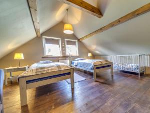 a attic bedroom with two beds and a crib at Holiday Home Jura dla Ciebie by Interhome in Cisowa
