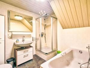 a bathroom with a shower and a sink and a tub at Apartment Am Malerwinkel by Interhome in Schieder-Schwalenberg