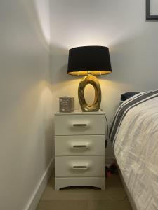a nightstand with a lamp on it next to a bed at Chambre suite privée à Boulogne in Boulogne-Billancourt