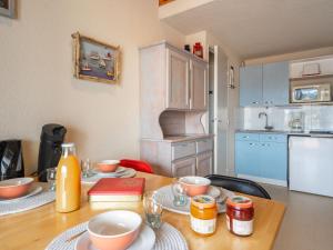 eine Küche mit einem Holztisch mit Schalen darauf in der Unterkunft Apartment Les Jardins de l'Océan-42 by Interhome in Vaux-sur-Mer