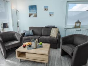 een woonkamer met een bank, 2 stoelen en een salontafel bij Apartment Ankerweg-2 by Interhome in Norddeich