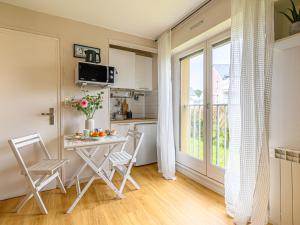 una piccola cucina con tavolo e sedie in camera di Studio Rose des Vents-2 by Interhome a Port-Haliguen