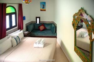 a room with two beds and a couch and a mirror at BELLEVUE HOUSE - with terrace in the heart of medina in Chefchaouen