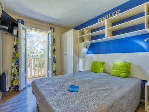 ein Schlafzimmer mit einem großen Bett mit grünen Kissen in der Unterkunft Holiday Home Domaine Golf Resort-2 by Interhome in Lacanau-Océan