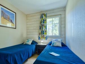 two beds in a room with a window at Holiday Home Domaine Golf Resort-2 by Interhome in Lacanau-Océan
