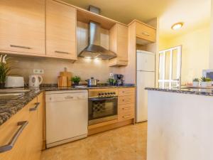 una cocina con electrodomésticos blancos y armarios de madera en Holiday Home Tatiana by Interhome, en Riumar
