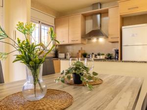 una cocina con una mesa de madera y un jarrón con flores en Holiday Home Tatiana by Interhome, en Riumar