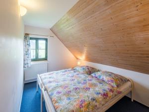 a bedroom with a bed with a wooden wall at Holiday Home Holiday Hill 40 by Interhome in Černý Dŭl