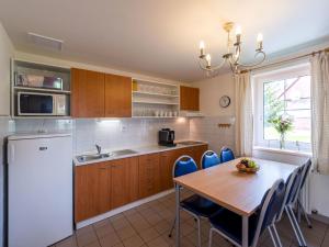 a kitchen with a wooden table and blue chairs at Holiday Home Holiday Hill 40 by Interhome in Černý Dŭl