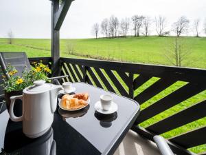 a table with a plate of croissants and cups on a balcony at Holiday Home Holiday Hill 40 by Interhome in Černý Dŭl