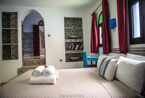 BELLEVUE HOUSE - with terrace in the heart of medina في شفشاون: غرفة نوم عليها سرير وفوط