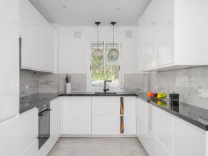 a white kitchen with white cabinets and a window at Apartment Marbella Real by Interhome in Marbella